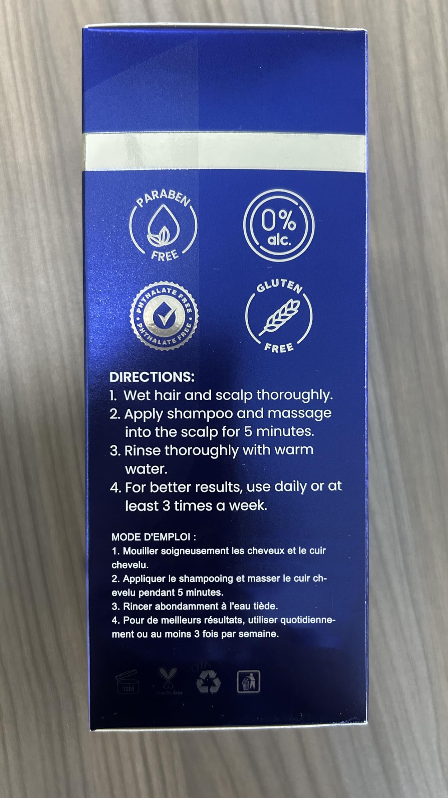 Side view of dark blue premium shampoo packaging showcasing professional strength follicle support