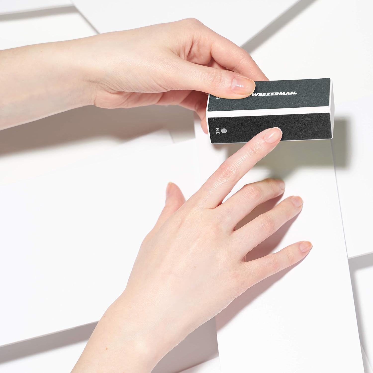 Close up of Tweezerman nail buffing block texture and labels