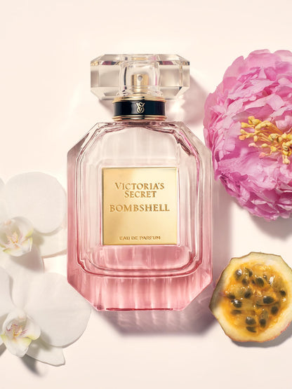 Luminous shimmer mist bottle from the Bombshell collection reflecting light against a neutral background
