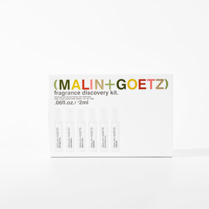An overhead flat-lay of the authentic imported MALIN+GOETZ fragrance discovery kit showing all six signature scents.