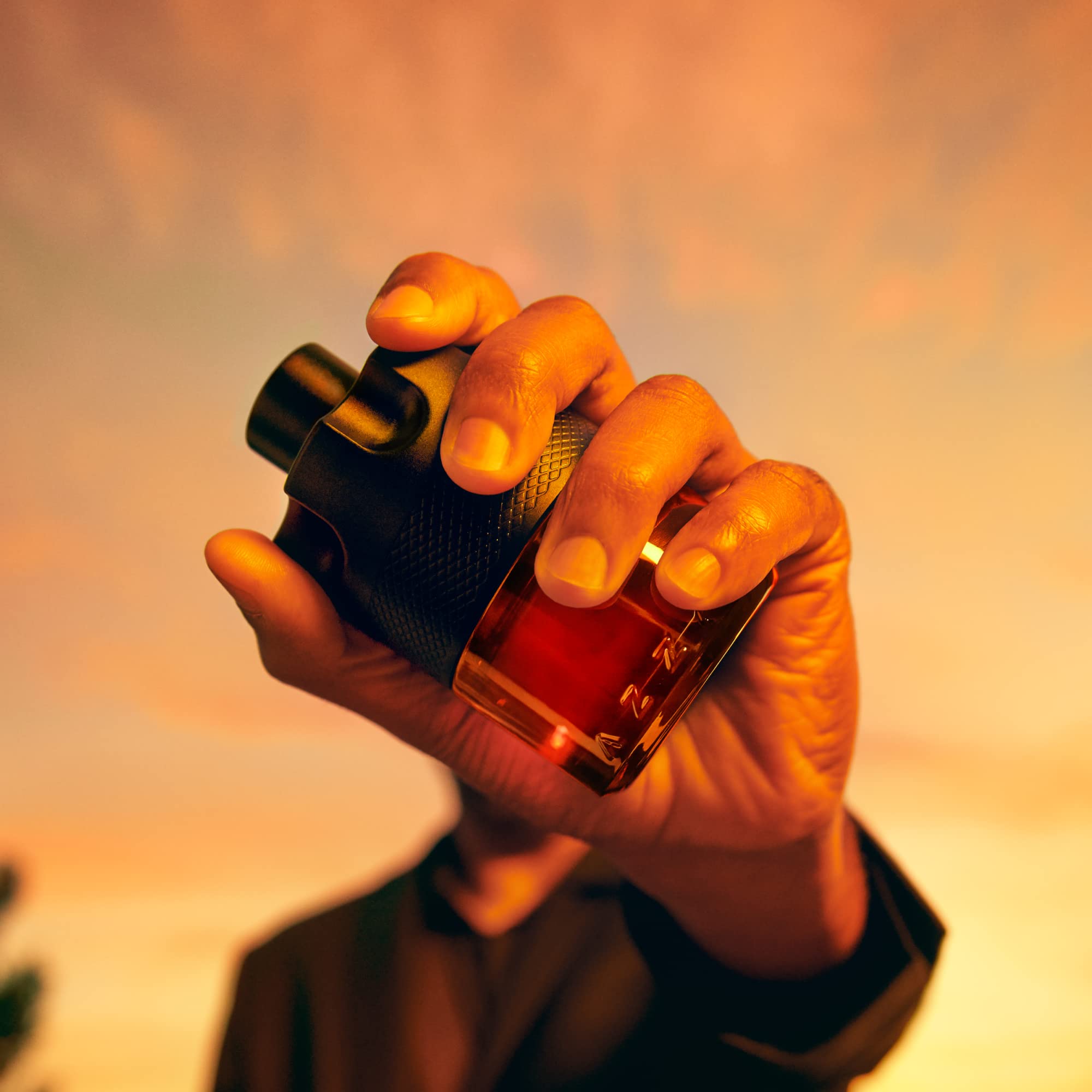 Side angle view of the semi transparent Azzaro masculine fragrance bottle revealing the amber liquid