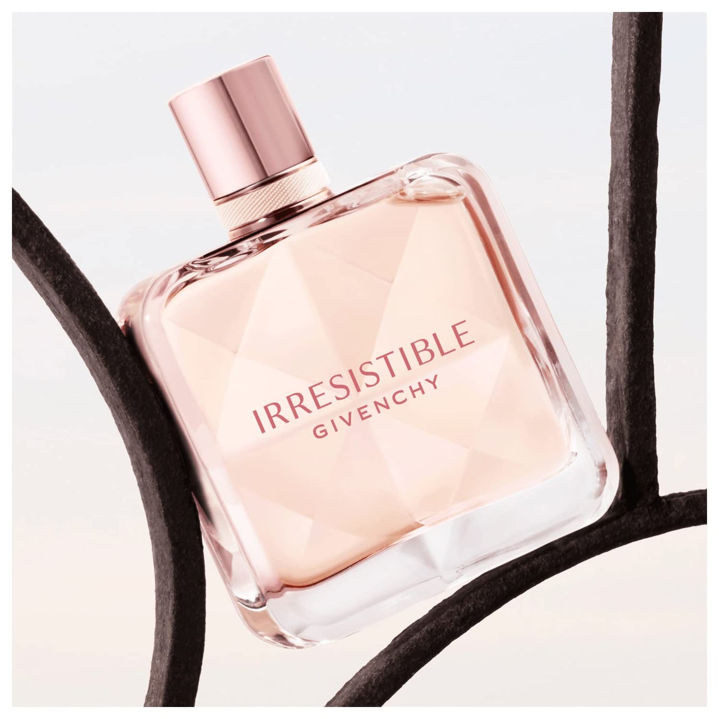 Side view of Givenchy Irresistible pink tinted glass perfume bottle