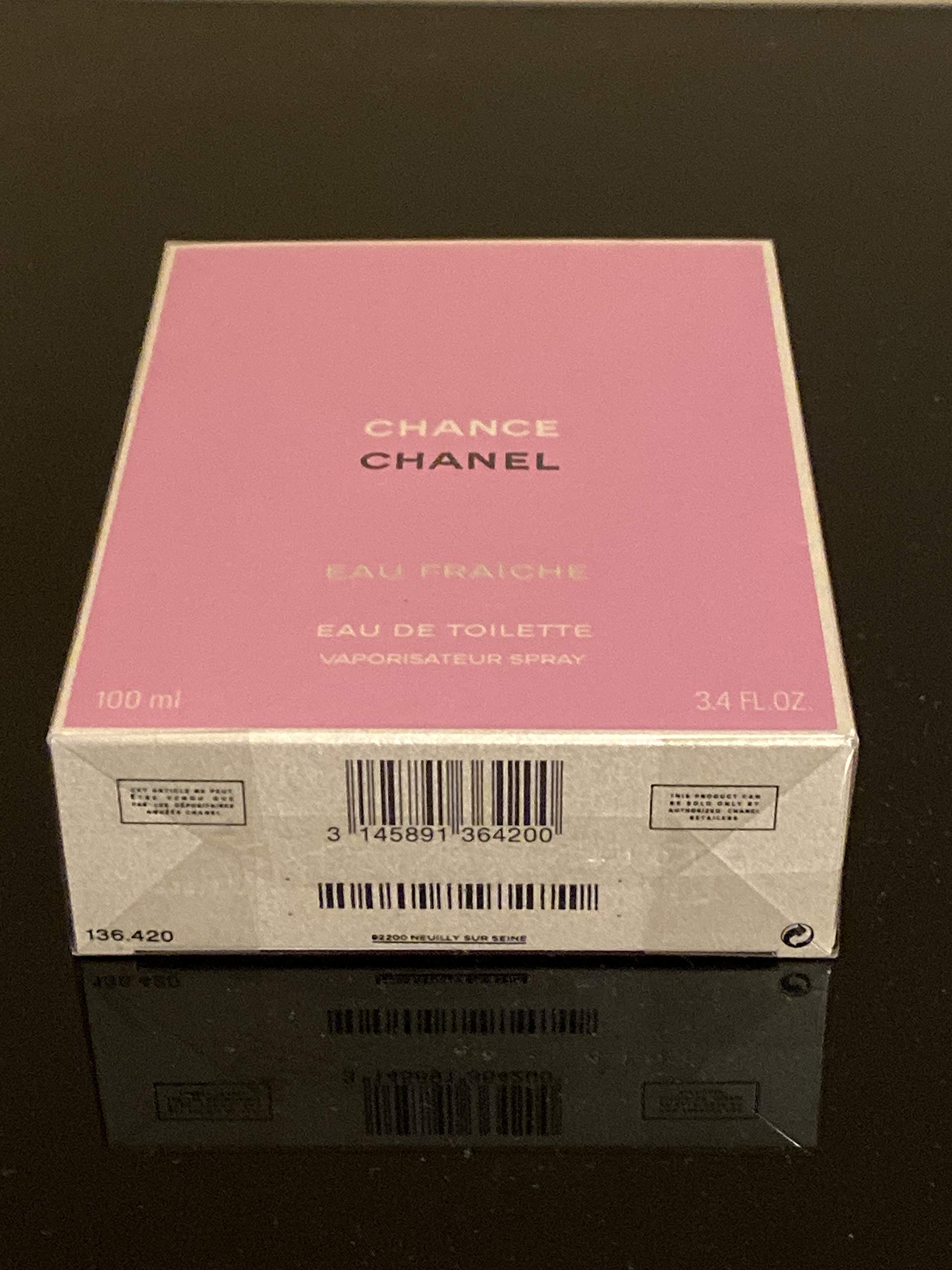 Side angle view of the elegant circular glass bottle of Chanel Chance Eau Fraiche luxury perfume spray for women.