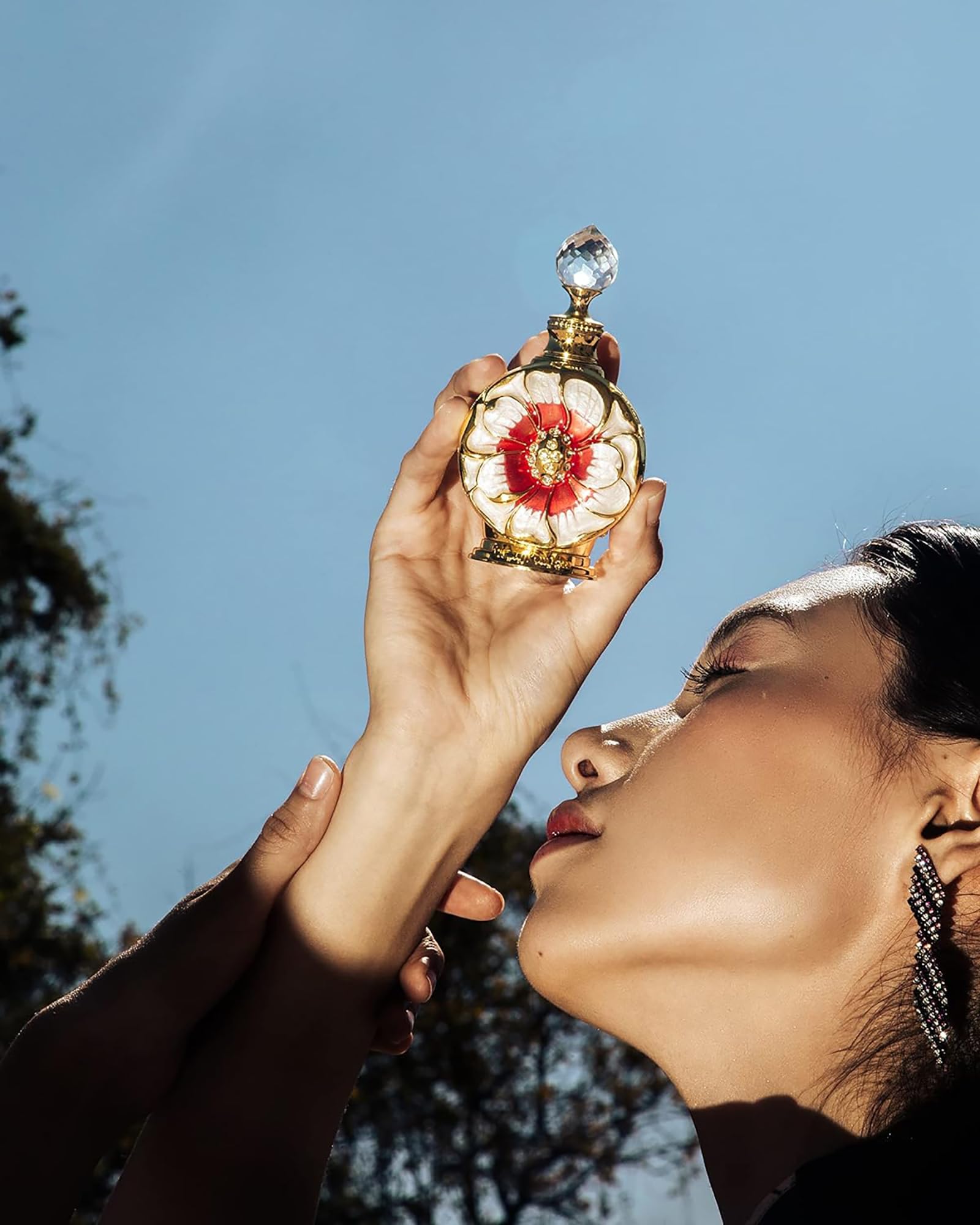Close up shot of the enamel flowers and gold accents on the Swiss Arabian Layali Rouge collectible fragrance packaging.