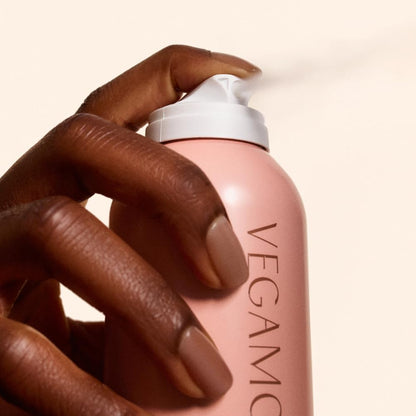 Vegamour volumizing hair spray being applied to roots for clean texture