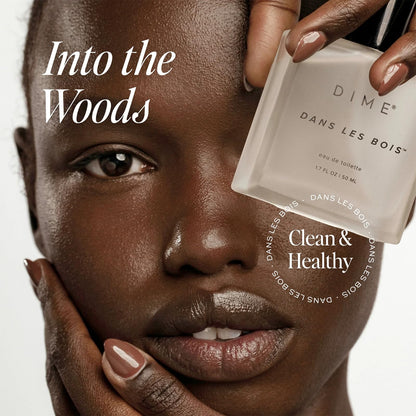 DIME Dans Les Bois 1.7 Ounce bottle on an elegant clean beauty setup.