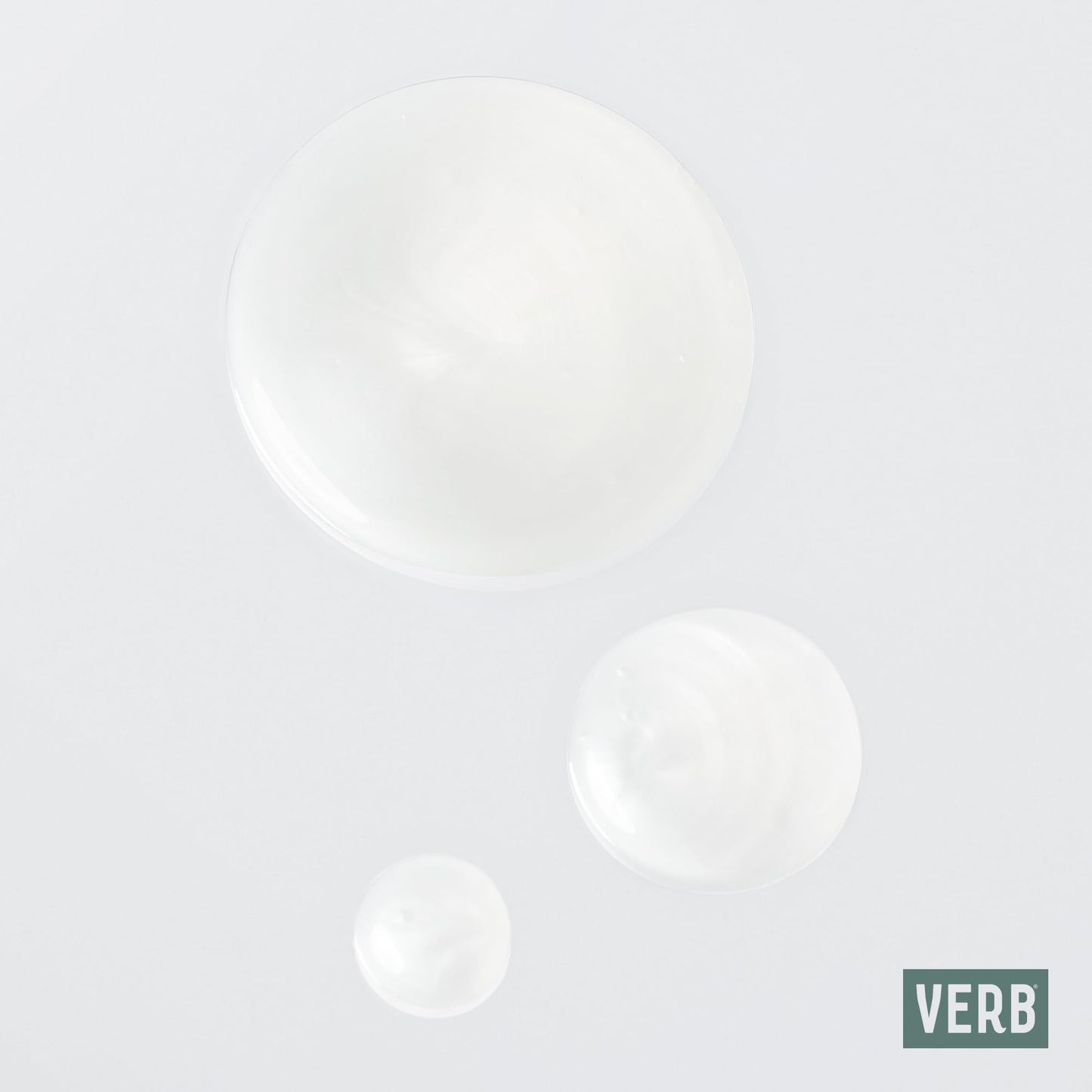 Texture shot of the lightweight Verb Ghost Shampoo and Conditioner liquids on a flat surface