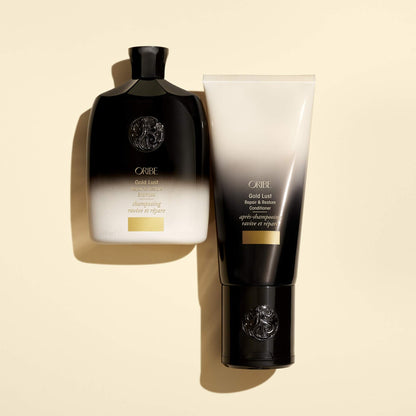 Oribe Gold Lust shampoo bottle held in hand showcasing the portable travel-friendly 8.5 ounce product size.