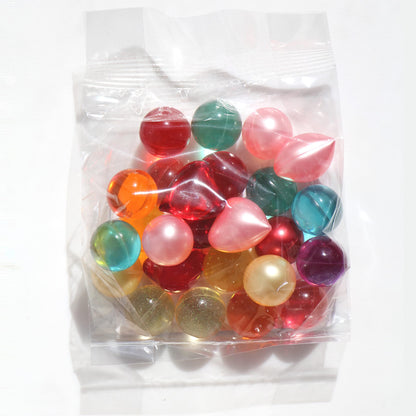 Nostalgic bath oil pearls in mixed colors held in a hand to show individual bead size.