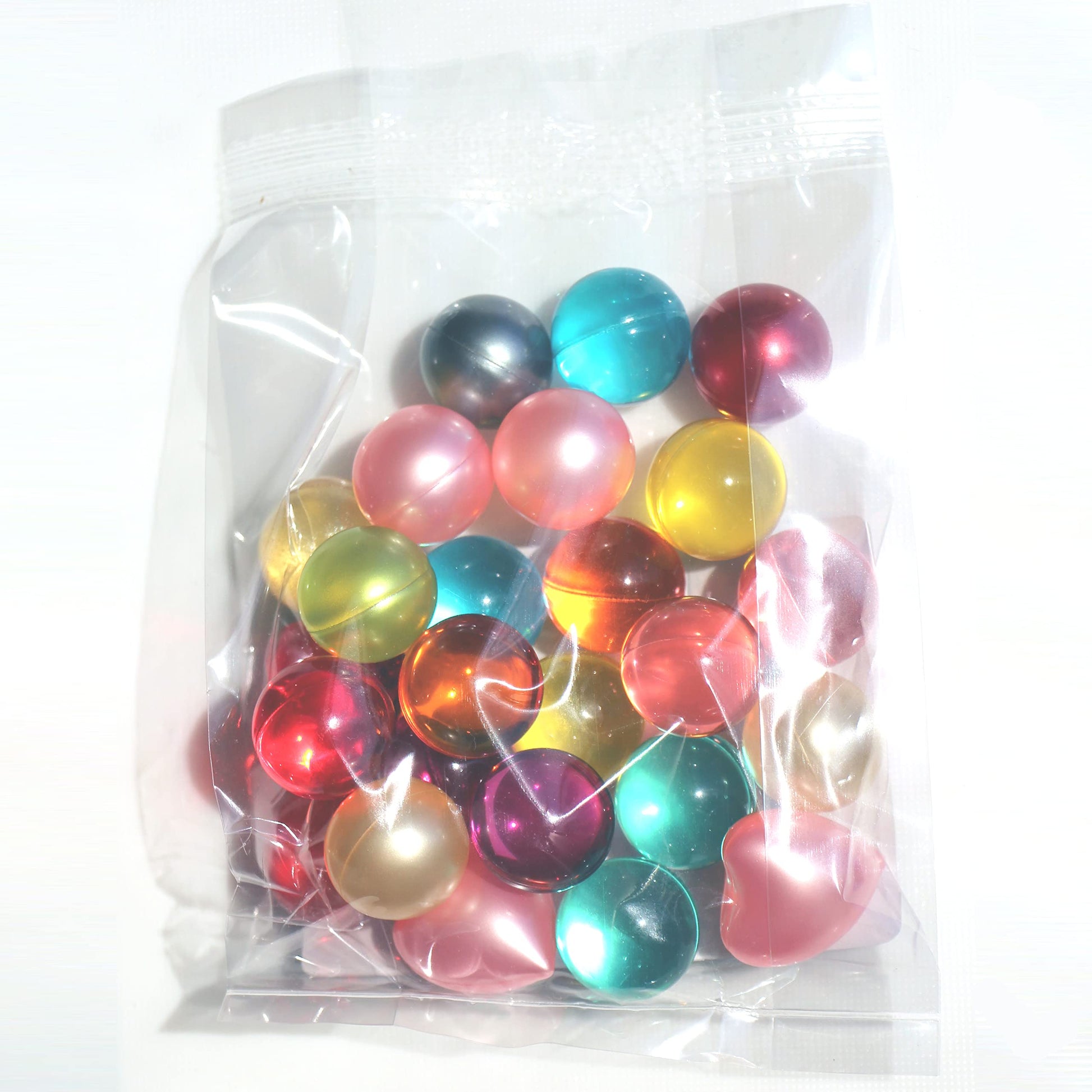 A collection of colorful round bath oil beads showcasing the different shades available.