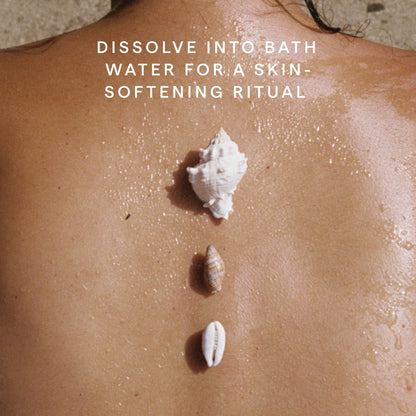 Spa setting with Herbivore Coconut Milk Bath Soak and towels