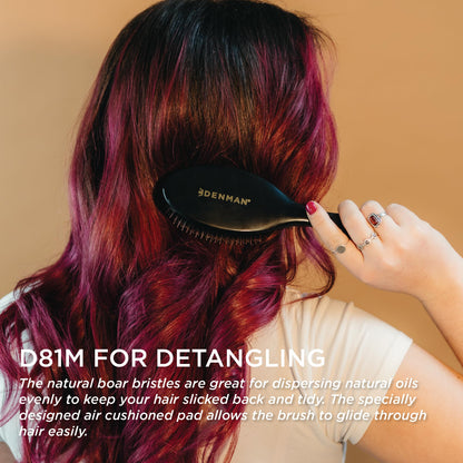 Ergonomic black handle design of Denman medium cushion hairbrush for grooming control.