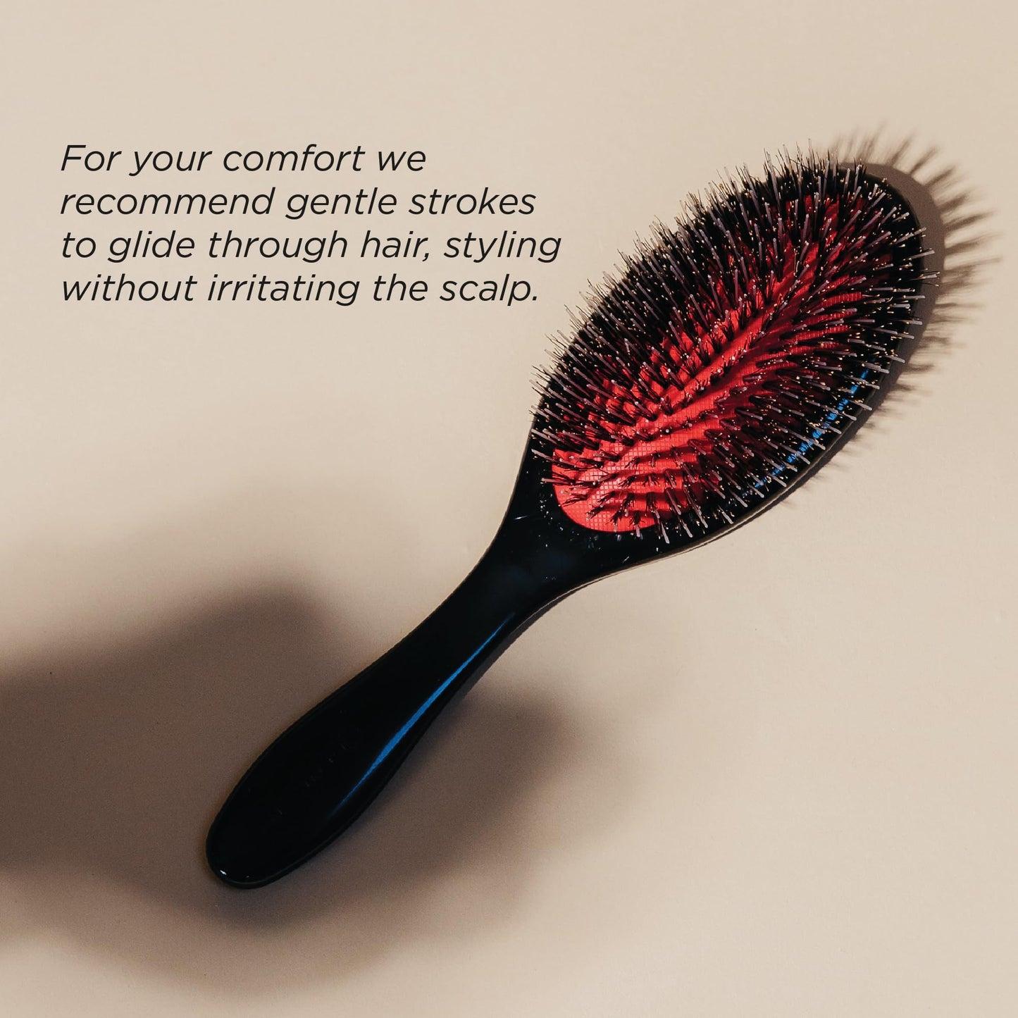 Denman boar bristle hair brush being used to define curls and tame frizz.