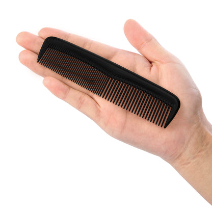 Compact black pocket comb held in hand for size reference