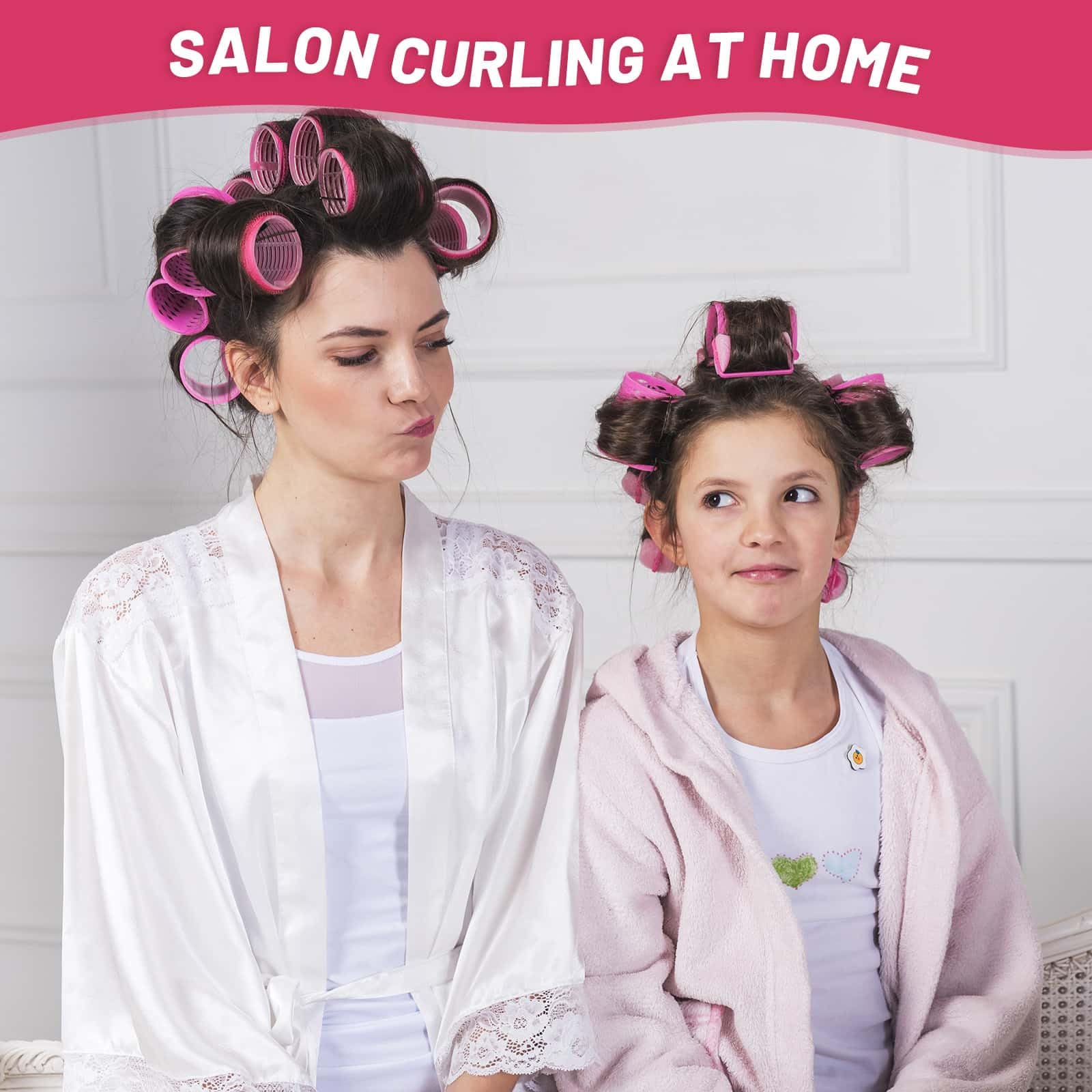 Twelve pieces of large pink velcro curlers arranged next to premium duckbill clips