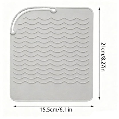 Heat proof styling station pad showcasing its universal compatibility with beauty tools