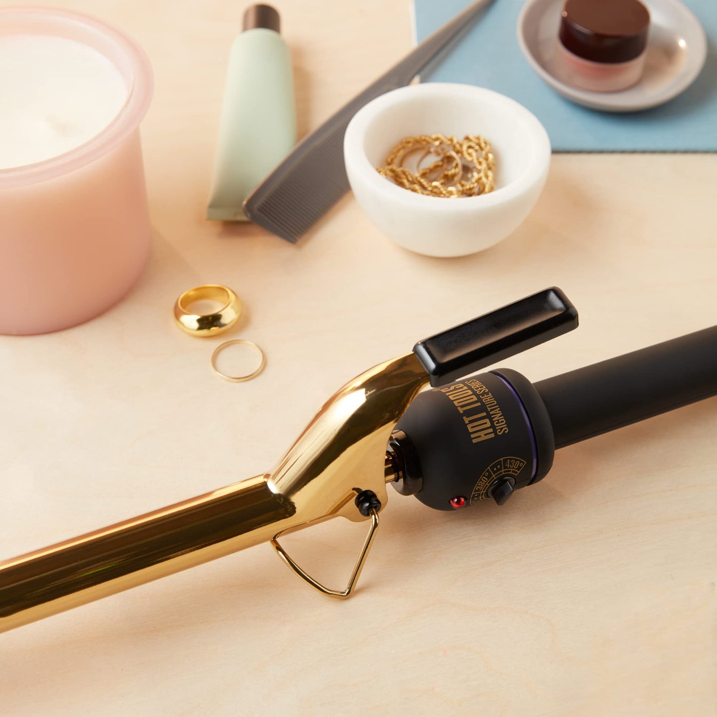 Hot Tools Pro Artist gold curling iron showcasing the sturdy spring clamp open for styling.