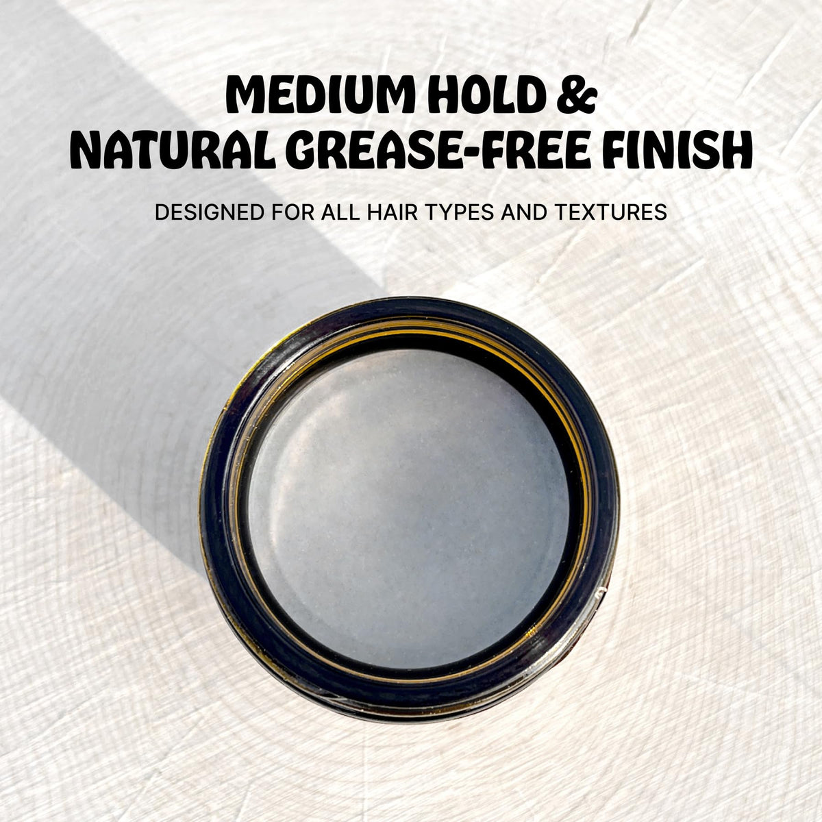 Earth Wave natural tallow grooming pomade next to its recyclable amber glass packaging.