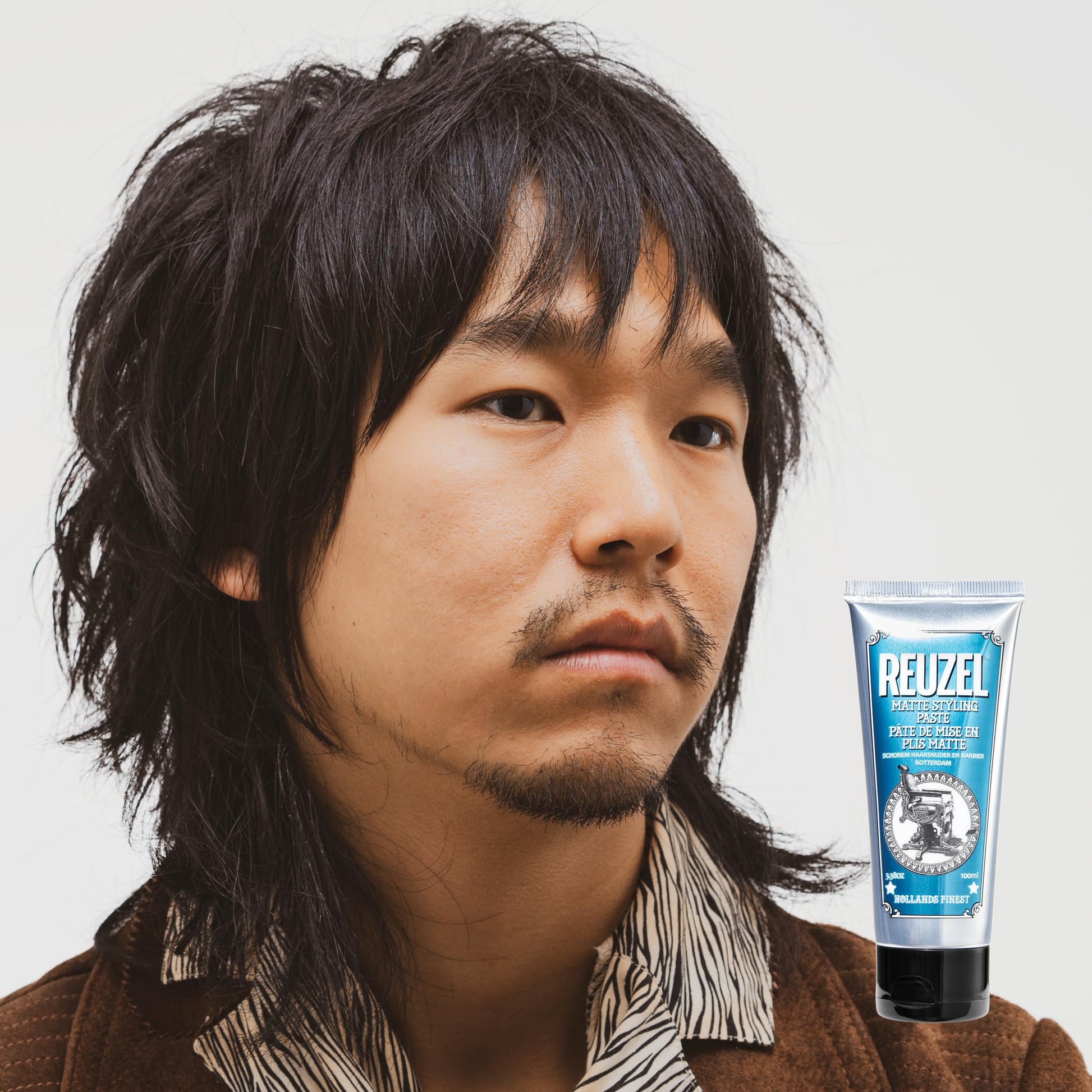Reuzel medium hold hair styling cream tube on a clean background for premium men grooming