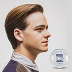 Open tin of Reuzel water-soluble styling wax displaying smooth clay pomade texture.