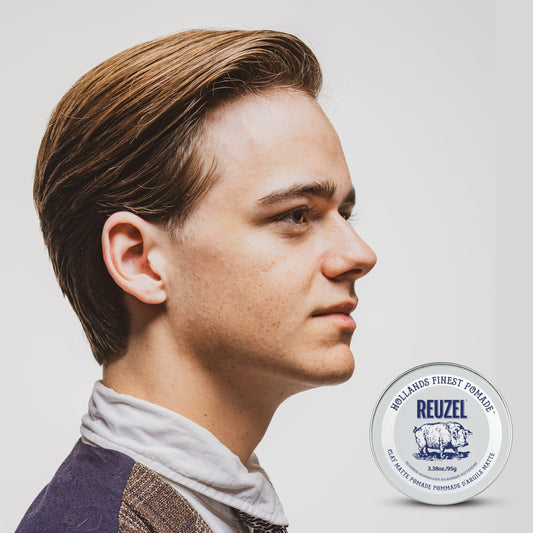 Open tin of Reuzel water-soluble styling wax displaying smooth clay pomade texture.