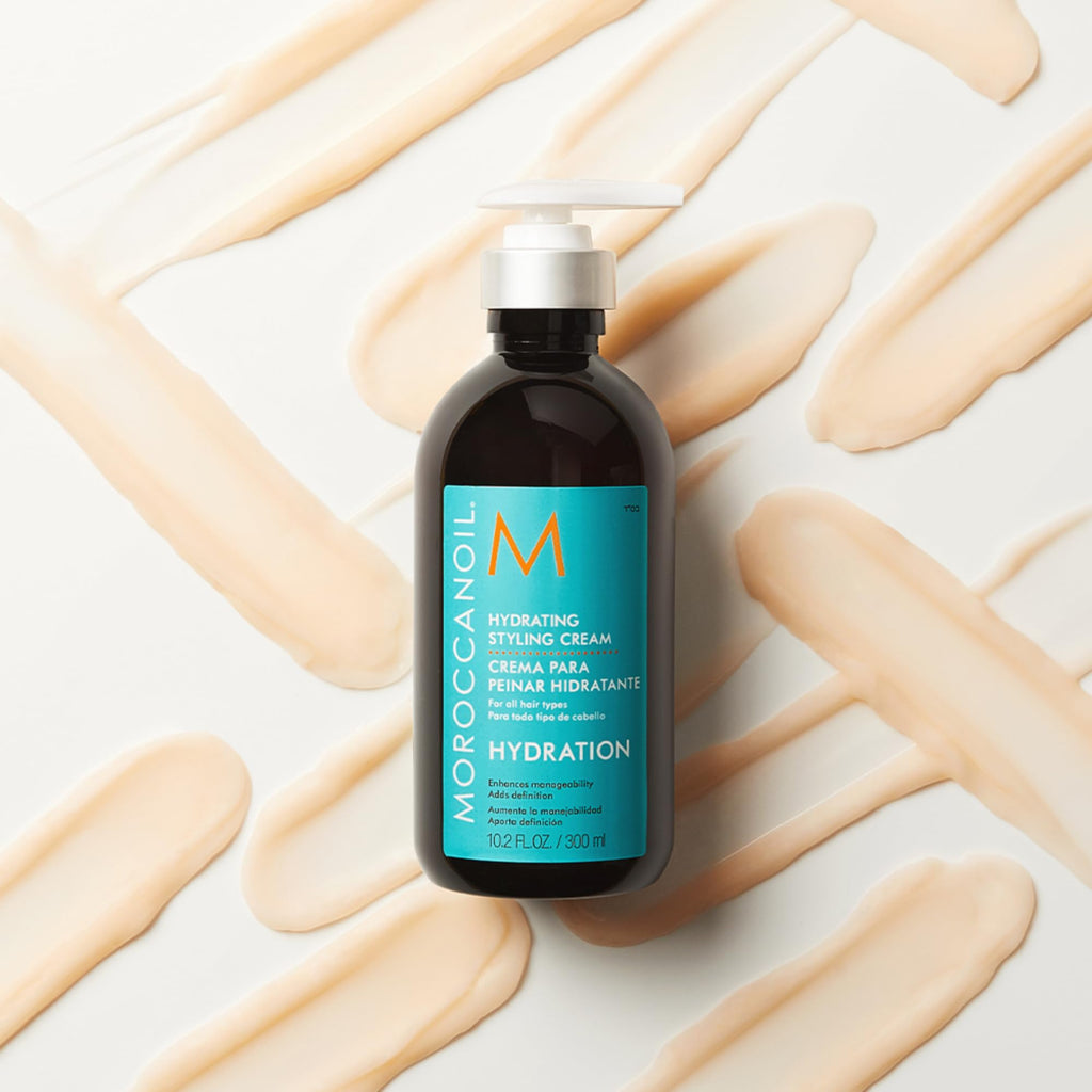 Moroccanoil Hydrating Styling Cream lifestyle shot of the argan oil infused hair product on a sleek vanity countertop.