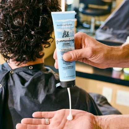 Texture shot of the lightweight styling cream formula next to the iconic blue Bumble and Bumble tube.