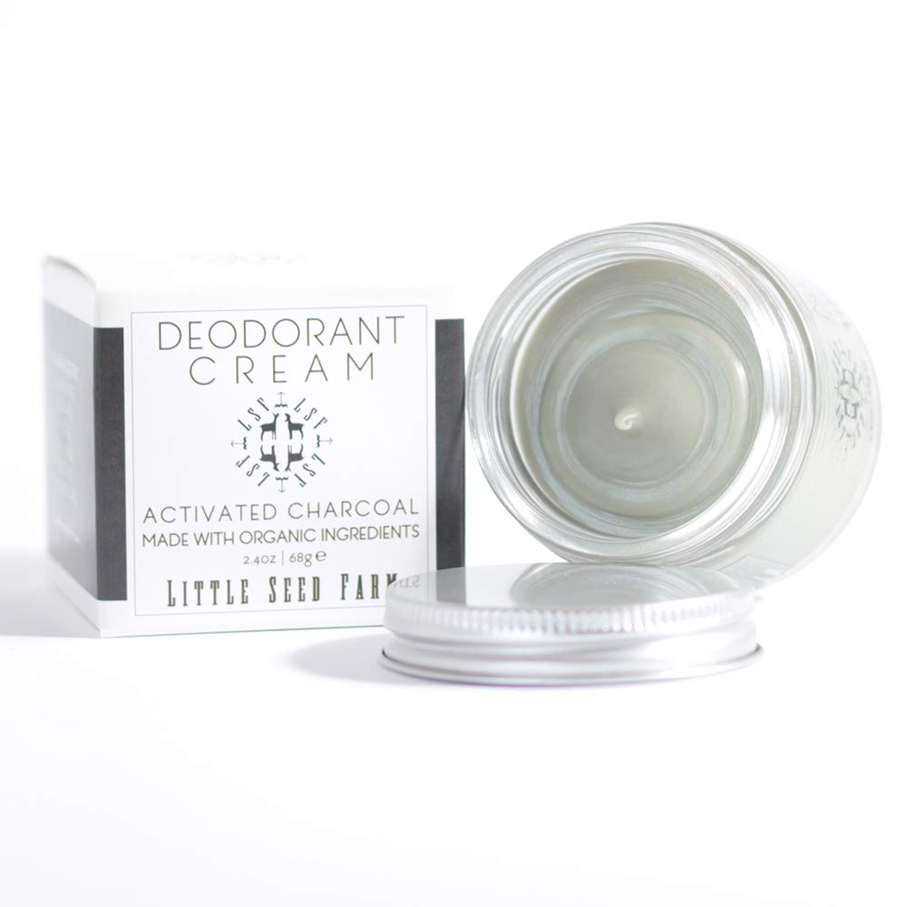 Applying a pea sized amount of natural charcoal deodorant paste on underarms