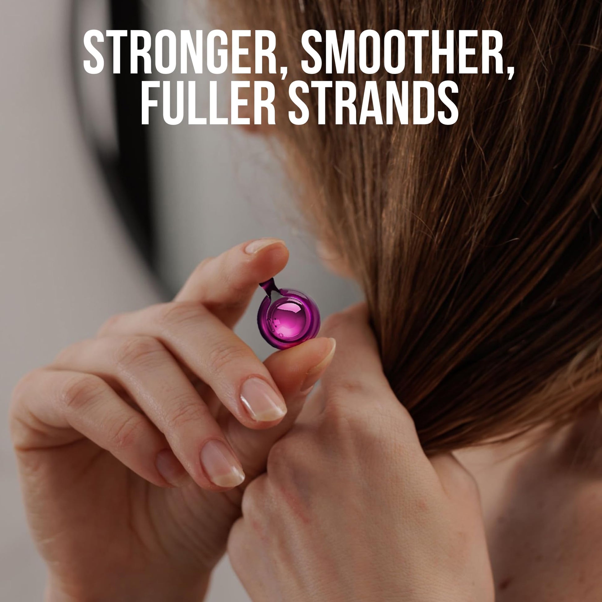 Close up of a person opening a single purple SAVION hair oil capsule
