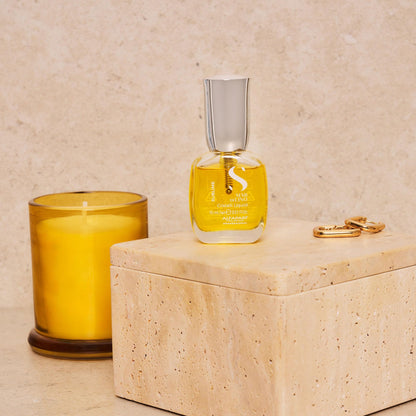 Pouring a drop of the golden flaxseed hair serum from the bottle to demonstrate its lightweight texture.