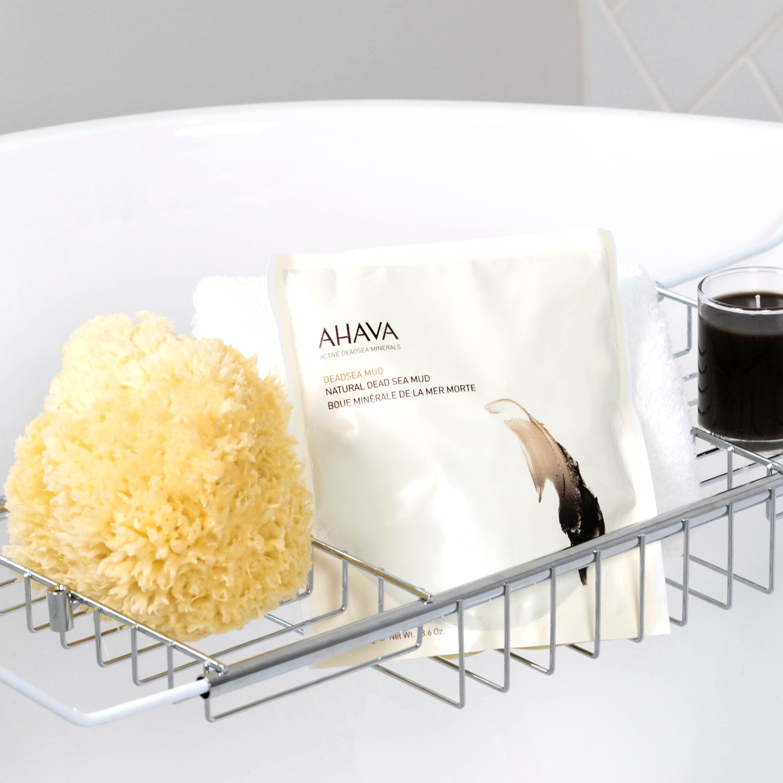 Warmed AHAVA body mud mask texture close up highlighting its rich and smooth consistency.