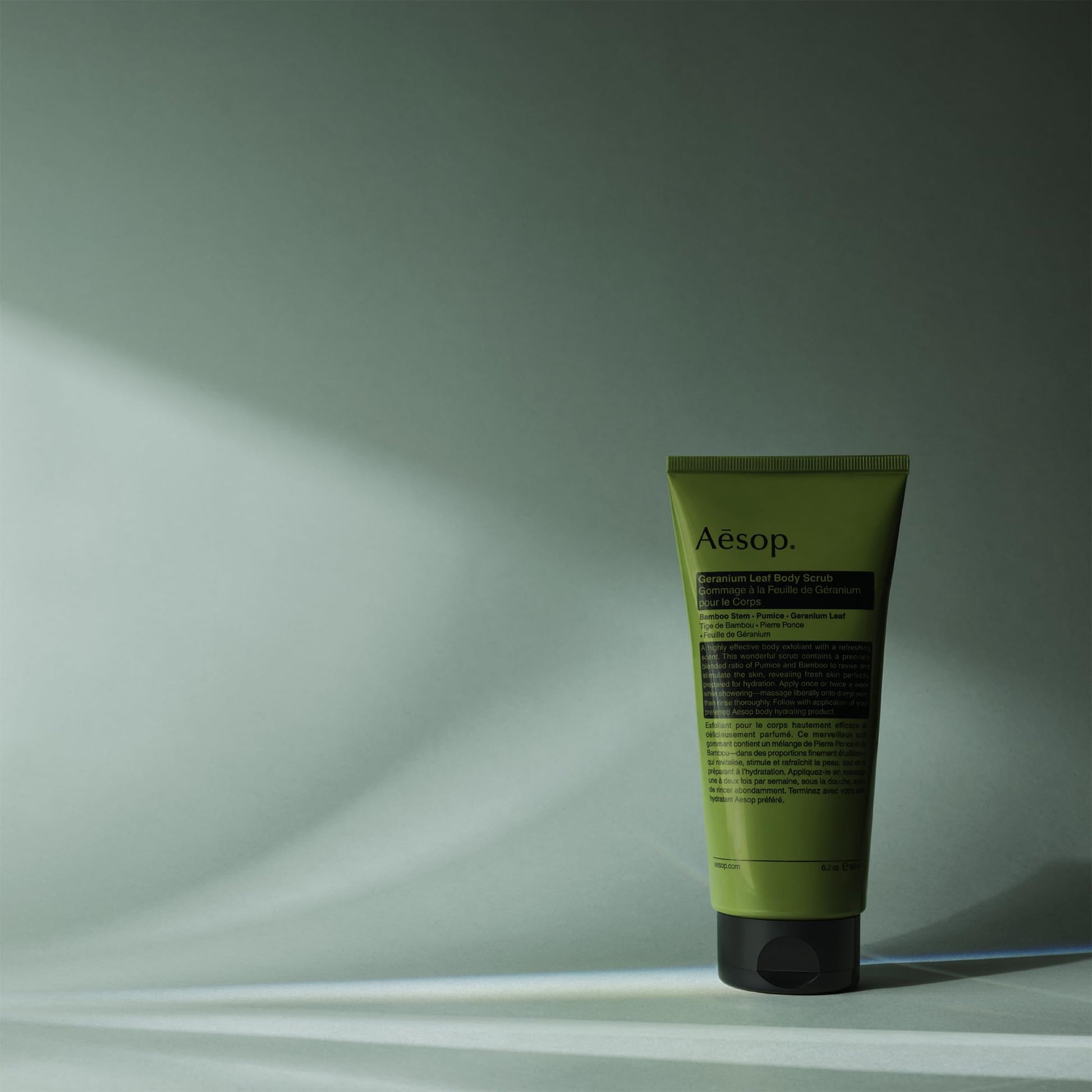 Aesop 180ml gel scrub tube held in hand showing size relative to packaging