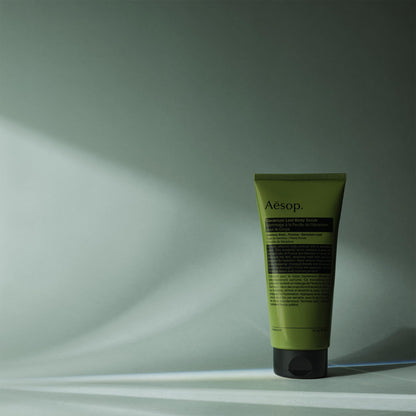 Aesop 180ml gel scrub tube held in hand showing size relative to packaging