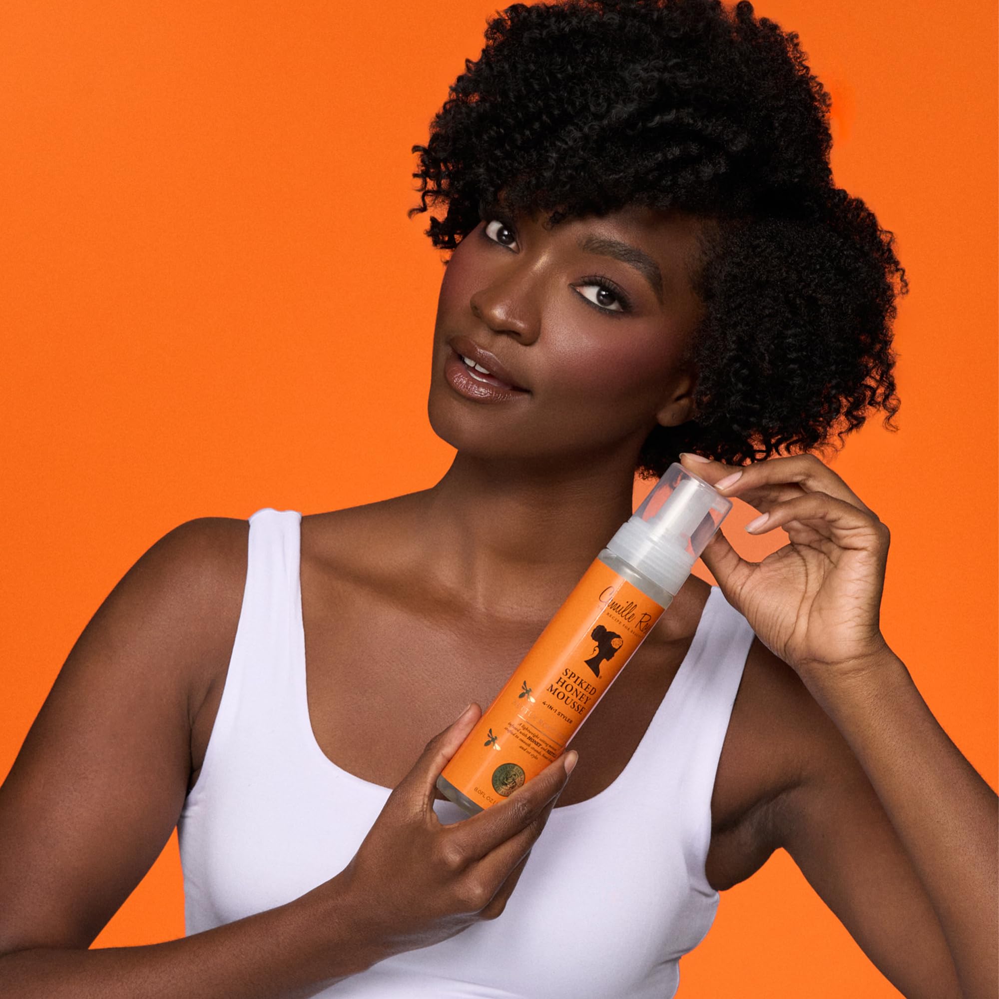 Lightweight styling mousse by Camille Rose displaying the clear pump bottle for easy application.