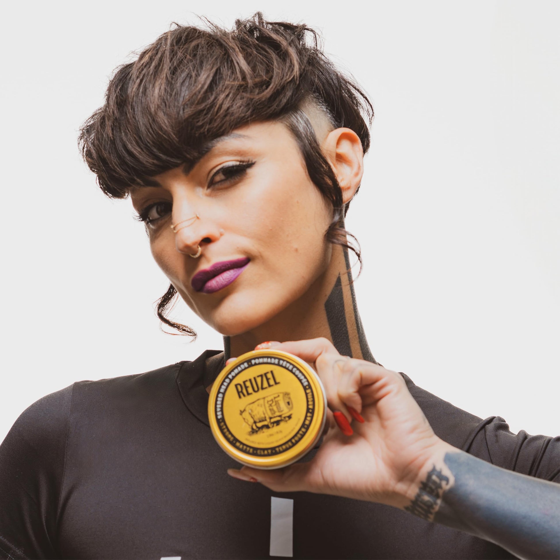 Reuzel Liquid Death non greasy hair clay pomade lifestyle shot with packaging
