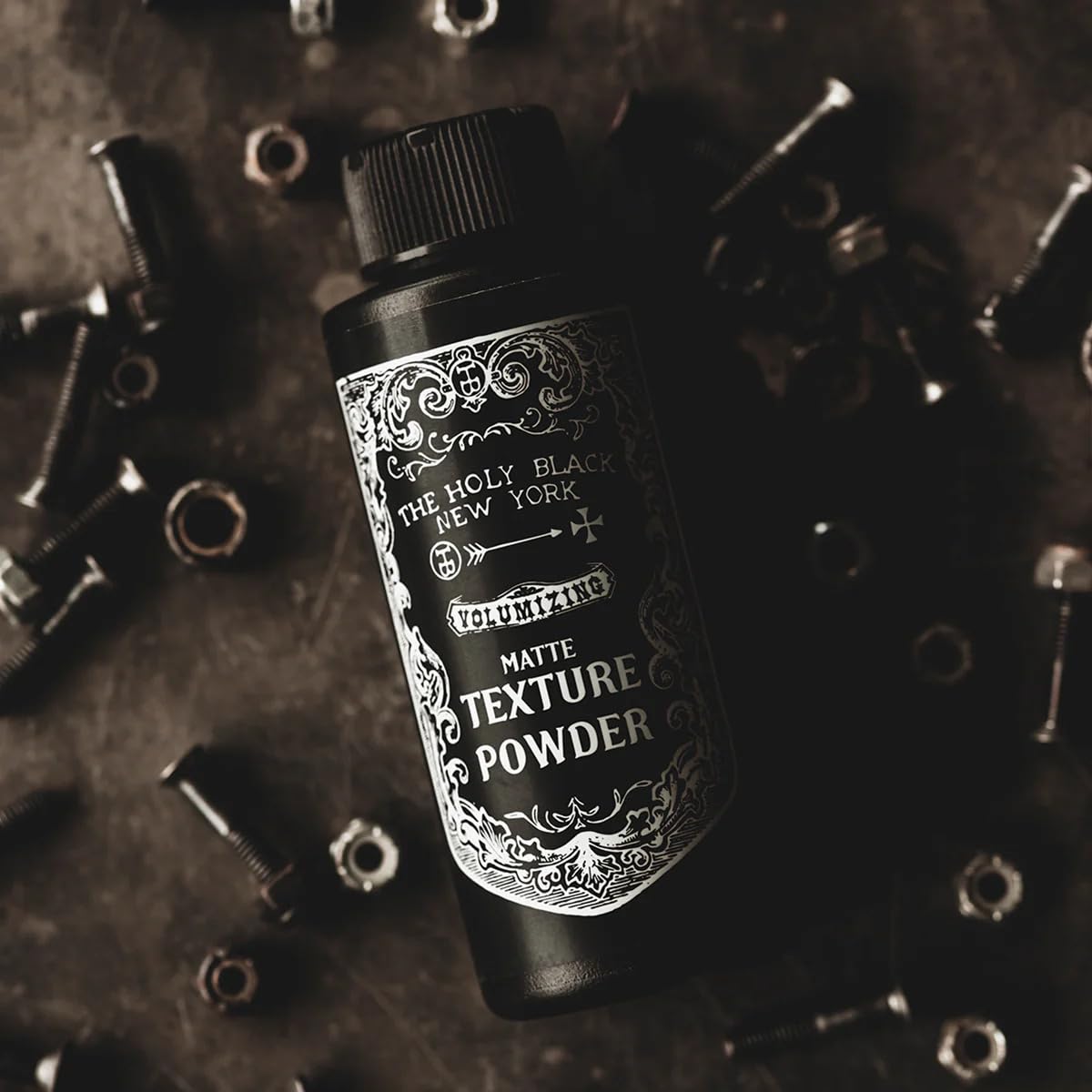 The Holy Black dry shampoo and texture powder bottle.