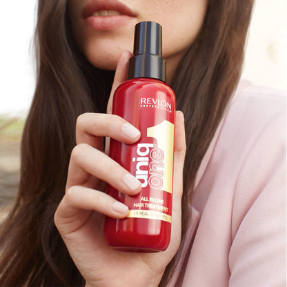 Revlon UniqOne hair treatment 150ml bottle held in hand