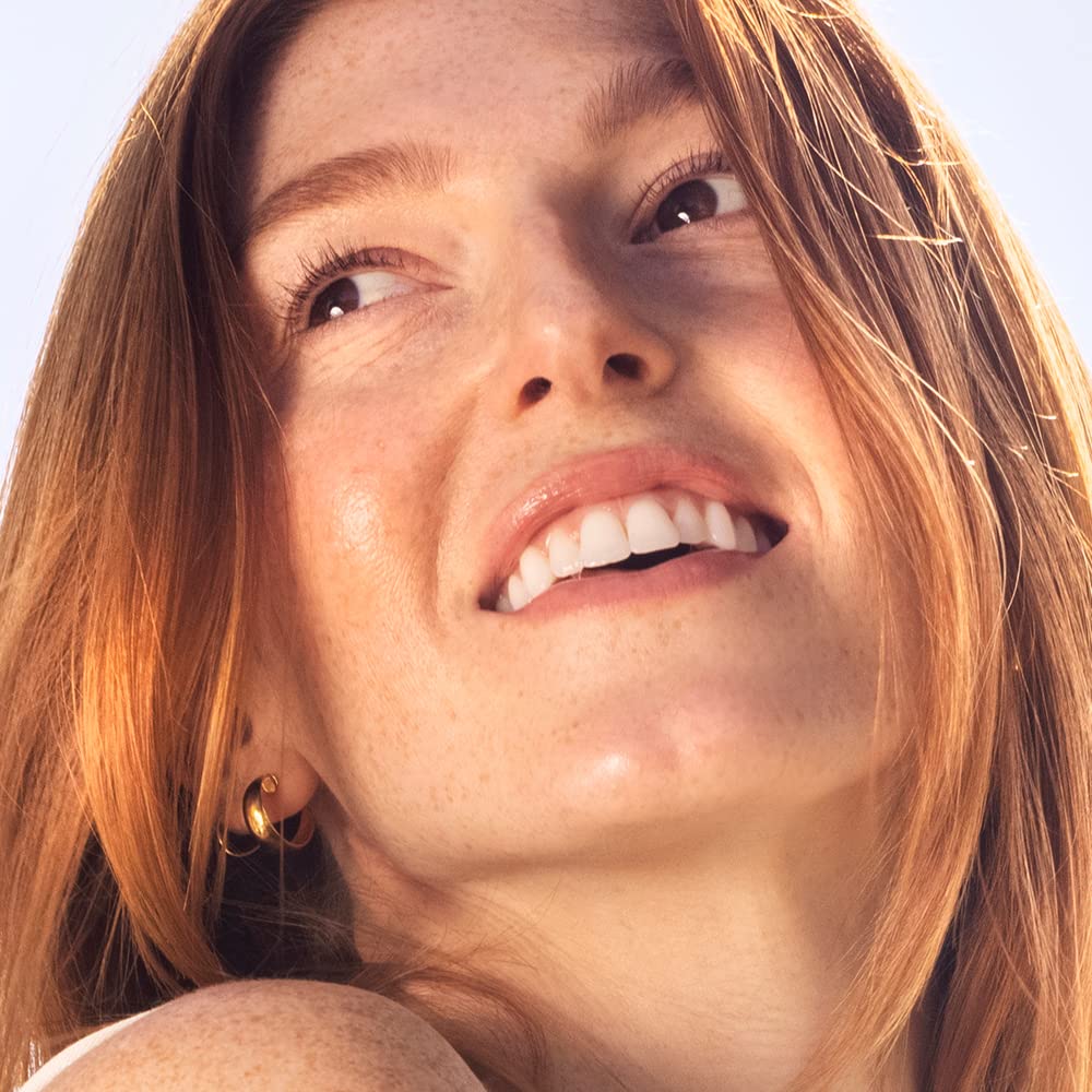 Person applying Sky Organics coconut oil to hair for treatment
