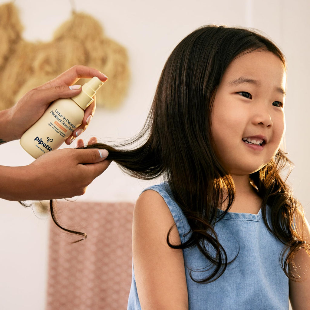Child hair brushing with pipette leave in detangler spray lifestyle