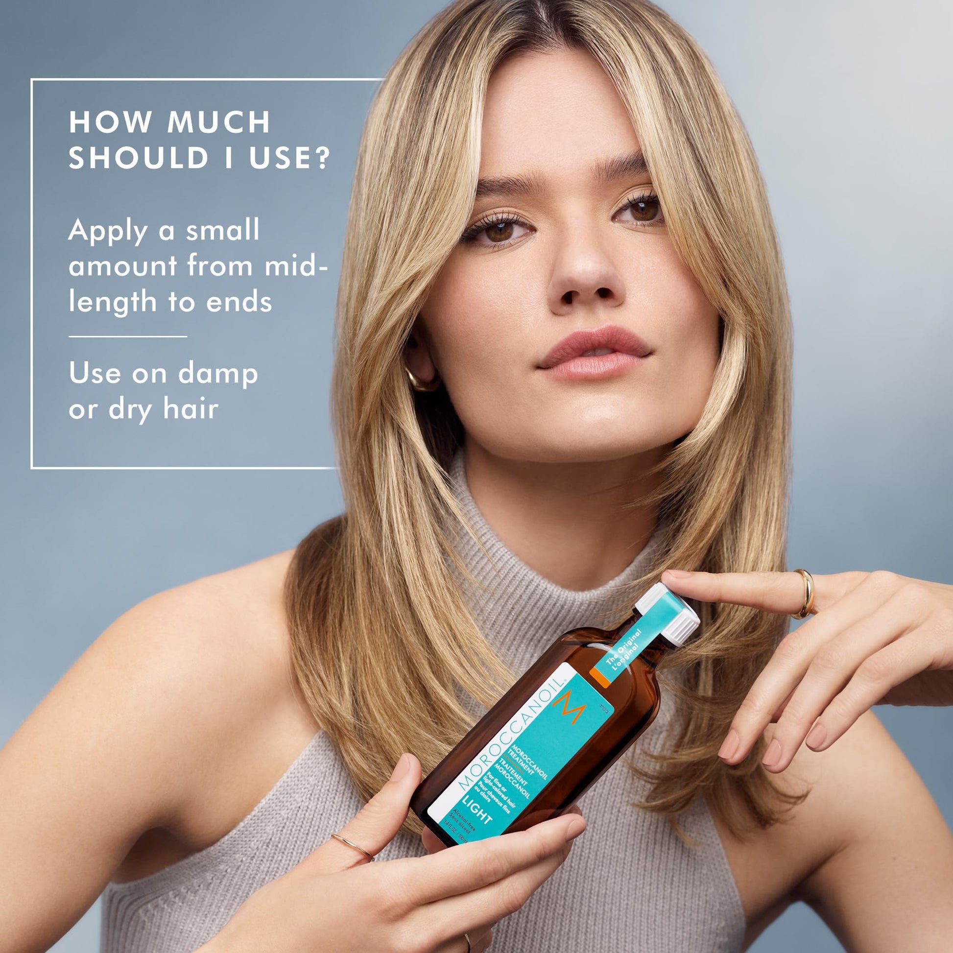 Applying Moroccanoil Treatment Light hair serum to the mid-lengths of fine blonde hair