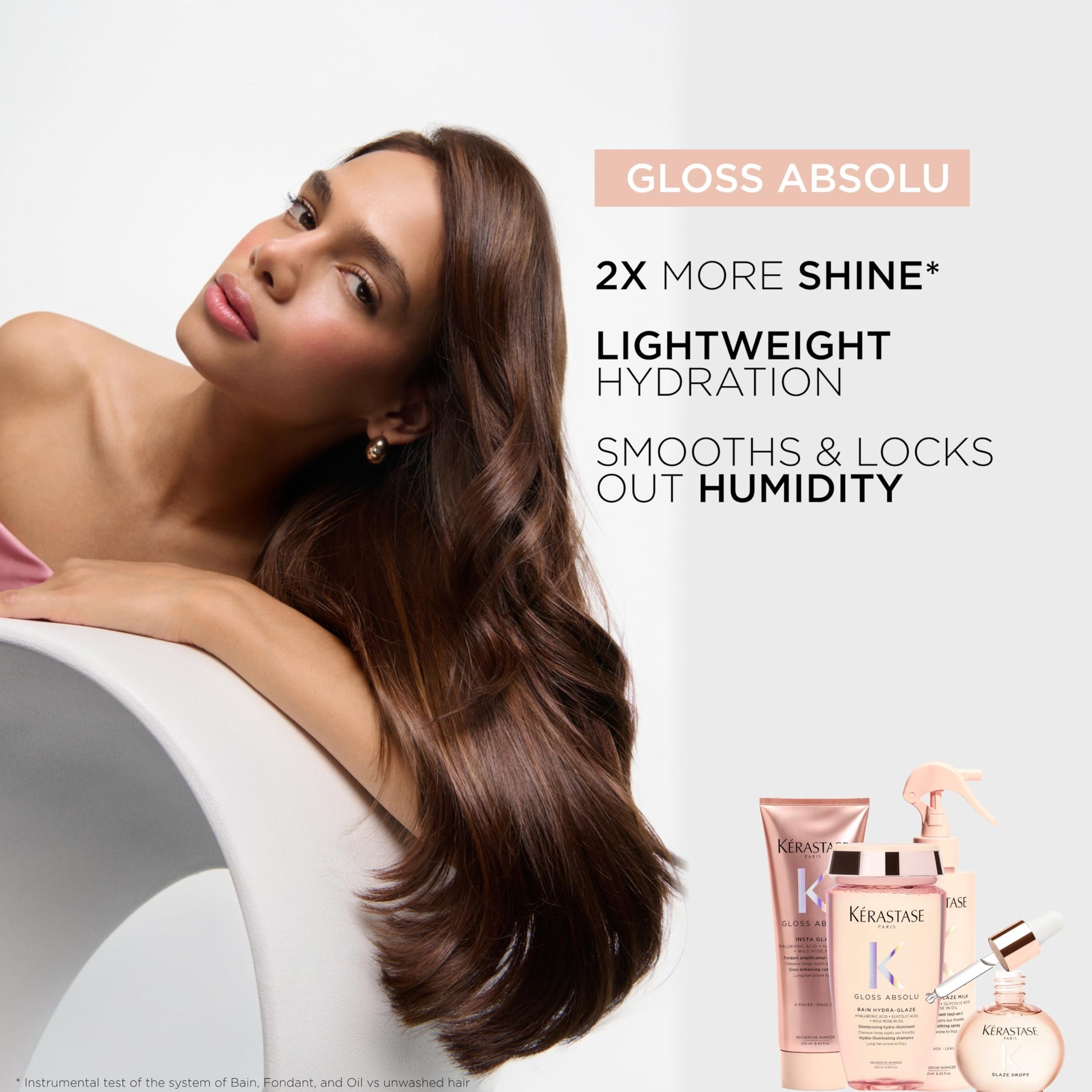 Application demonstration showing drops of the clear KÃ©rastase serum being dispensed into palms for styling.