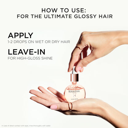 KÃ©rastase Gloss Absolu bottle next to wild rose elements emphasizing the nourishing botanical formulation.