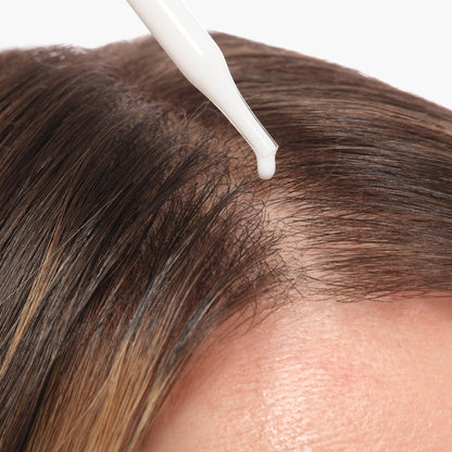 Applying The Ordinary scalp serum to hair roots for hydration