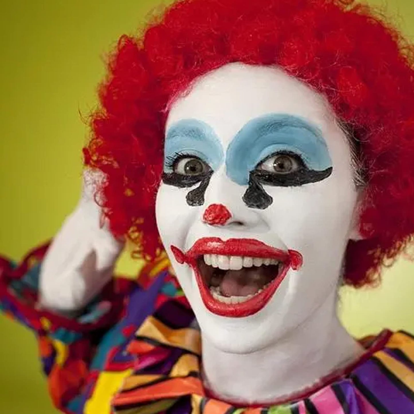 White clown paint base being applied with a damp makeup sponge.
