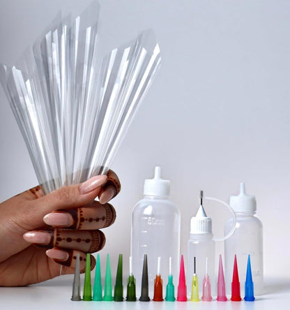 Close up view of the three reusable plastic applicator bottles with volume markings included in the DIY mehendi set.