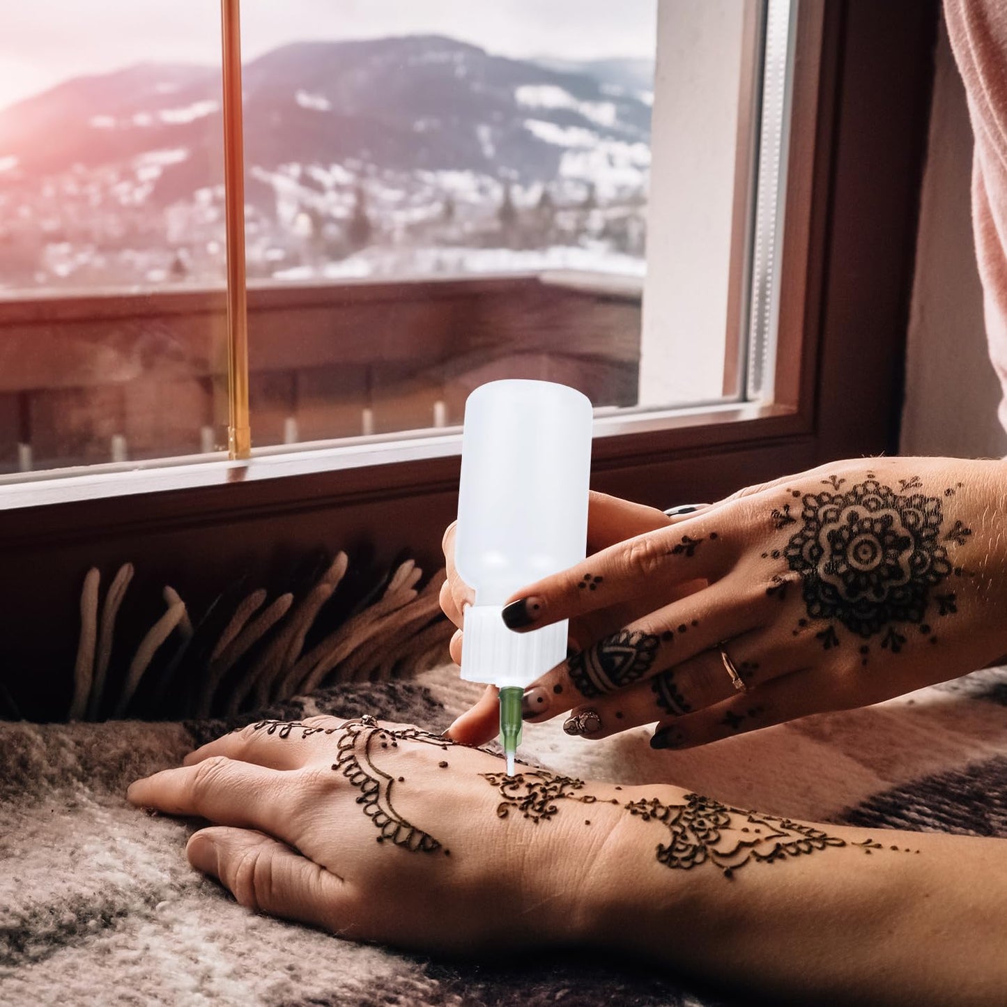 Fine tip needle applicator rendering intricate geometric lines for a temporary jagua tattoo design.