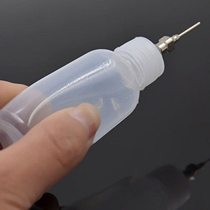 Soft squeeze plastic craft bottle being prepared for intricate temporary tattoo application.