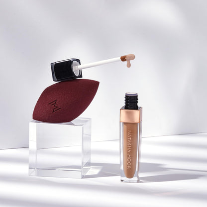 Model applying Natasha Moor Liquid Magic Concealer under eyes
