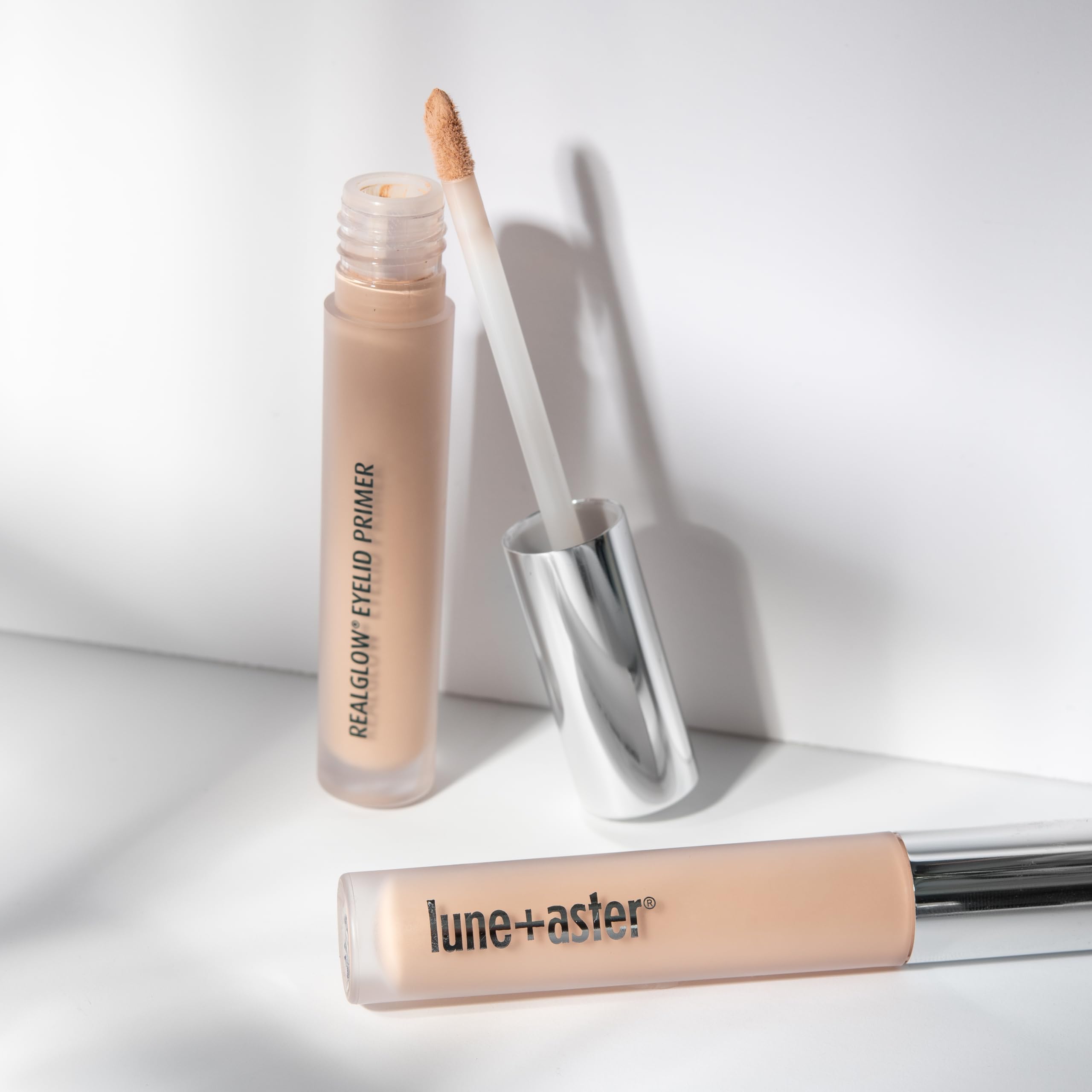 Close up view of the Lune and Aster vegan eyeshadow primer bottle highlighting key ingredients.