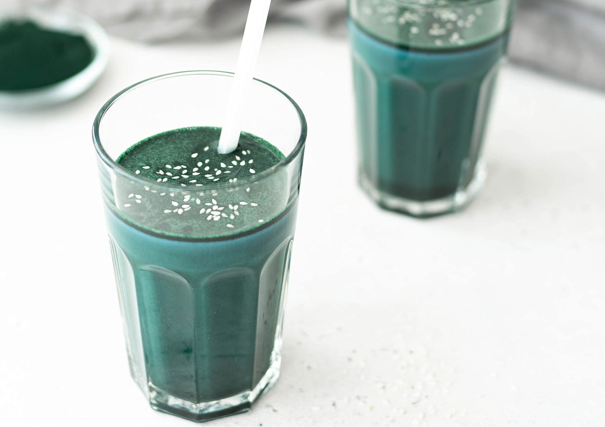 Scoop of green algae powder showing fine texture